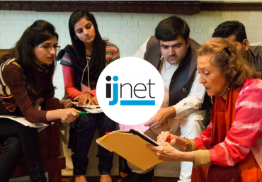 People grouped together discussing with the ijnet logo on top