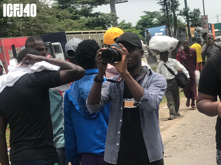 A photograph of Olakunle Mohammed holding a camera in a crowd on people.