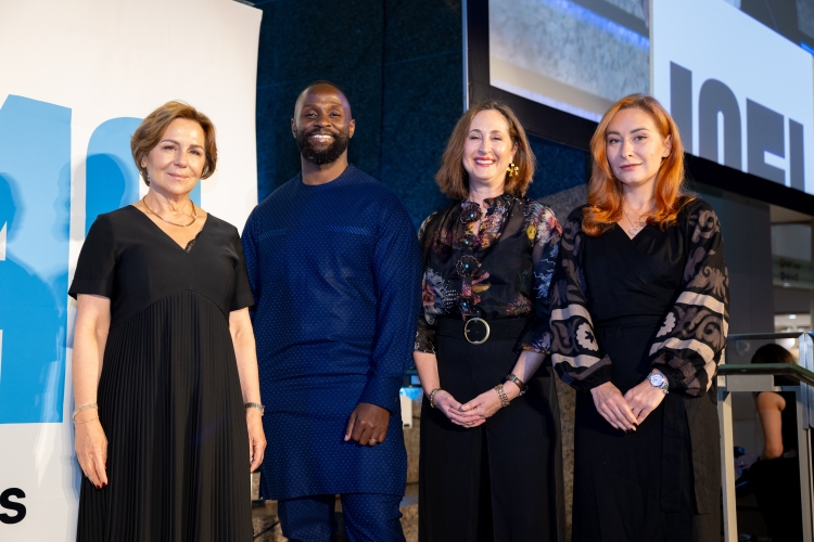 At the 2024 ICFJ Tribute to Journalists, three award winners pose for a photo on stage with the ICFJ president.
