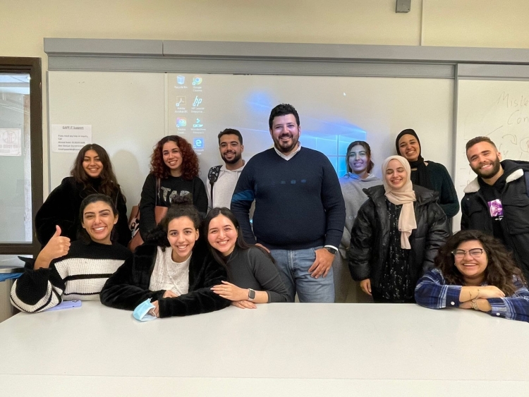 Group photo of a classroom of students with Eleraqi in a classroom setting.