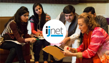 People grouped together discussing with the ijnet logo on top
