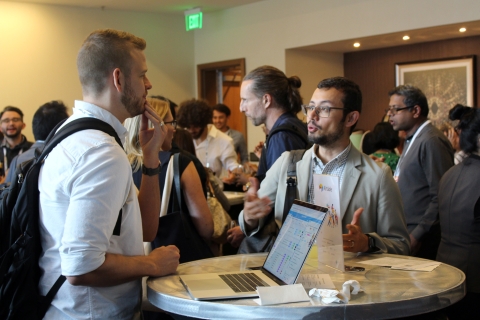 ICFJ Knight Fellow Pedro Burgos speaks with a fellow panelist at ONA18.