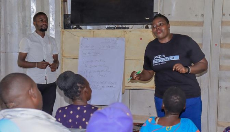 A photo of Harriet Atyang presenting to a room of people.