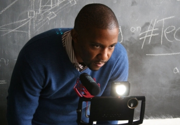 Photo of a man looking through a camera